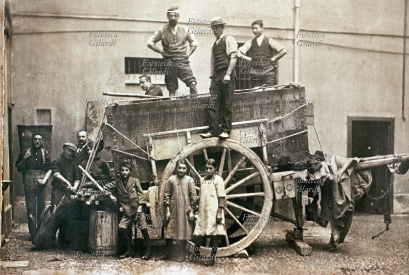 VINO Fotografia ricordo al termine di una vendemmia dei primi anni del 1900. Sul carro colmo del raccolto, due uomini pigiano l\