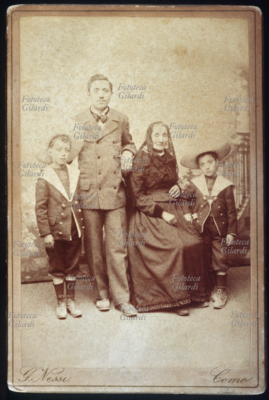 FAMIGLIA La bisnonna posa insieme al nipote e ai suoi due figli maschi, vestiti alla marinara. Provenendo dalla ricca campagna comasca, si fanno immortalare in un prestigioso atelier del capoluogo. Foto G. Nessi, Como, fine del XIX secolo
