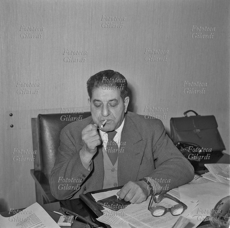 Giuseppe DI VITTORIO (11 agosto 1892 – 3 novembre 1957) ritratto alla sua scrivania mentre si accende una sigaretta. Militante nel Partito Socialista fino al 1924, aderì poi al Partito Comunista. Fu segretario generale della CGIL (1945-1957) e della Federazione sindacati mondiali (1949-1957). Fotografia di Ando Gilardi (1921 - 2012) #andogilardi, Italia 1955 circa.