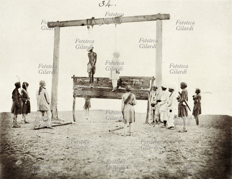 ESECUZIONE di due ribelli indiani, da parte del governo britannico, per mezzo di impiccagione. Si tratta di soldati indiani del reggimento Sikh a cavallo al comando del Regno Unito. La rivolta, passata alla storia come Indian Mutiny o Rivolta dei Sepoy, venne repressa nel sangue. Fotografia di Felice A. Beato, 1858