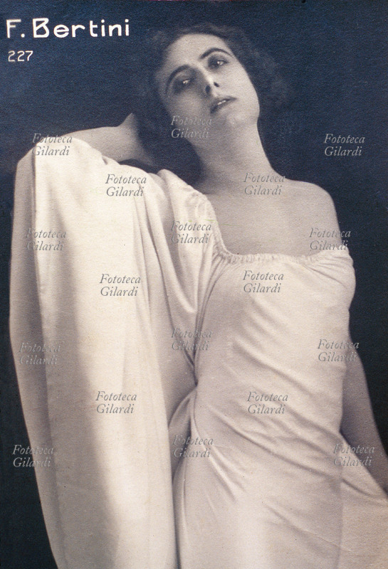 Francesca Bertini (1892) actress. Portrait in the most adherent white dress with a wide handle to cape. Its reputation of beautiful and fatal woman gave origin to the divismo in Italy. Taken part to beyond 90 films, some: Assumed Thorn (1915), Fedora (1916), nude woman (1918). Rome, 1915 approximately.