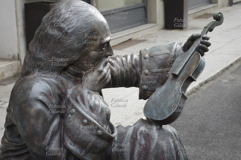 Antonio STRADIVARI (1644 – 18 dicembre 1737) scultura in vetroresina posta su una panchina, che raffigura il sommo liutaio cremonese seduto, nell\