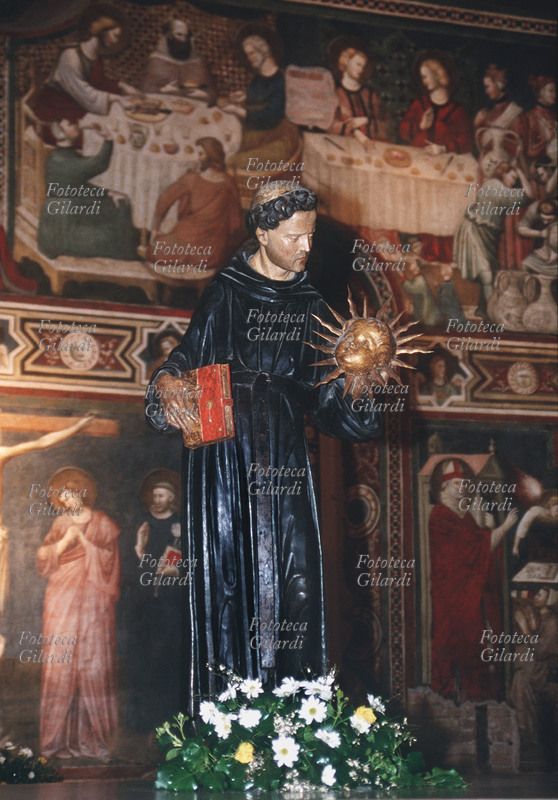 SAN NICOLA da Tolentino (1245 – 10 settembre 1305), al secolo Nicola di Compagnone, taumaturgo. Scultura lignea, in mano a San Nicola: il libro della Regola e il Sole raggiato, emblemi del Santo, nel Cappellone di San Nicola nella Basilica omonima di Tolentino. Fotografia di Elena Piccini, Italia XXI secolo.