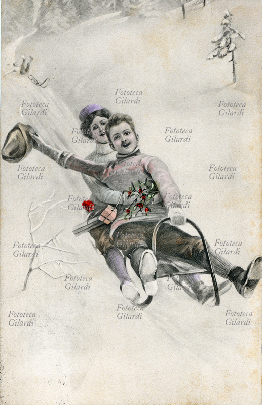 COPPIA di giovani scivolano allegramente con uno slittino; tra le mani un rametto augurale di vischio e piccoli pacchetti regalo. Litografia mocromatica acquarellata, Vienna 1909