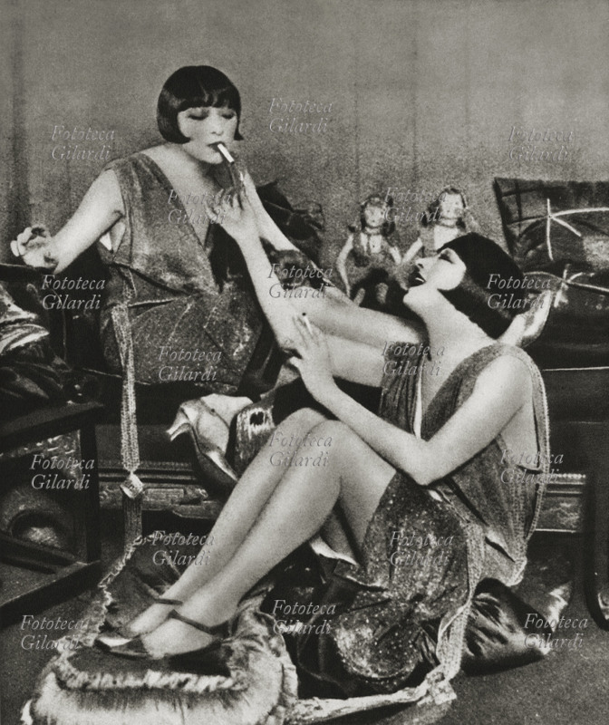 EMANCIPAZIONE femminile. Due amiche fumano in compagnia. Fotografia dell\