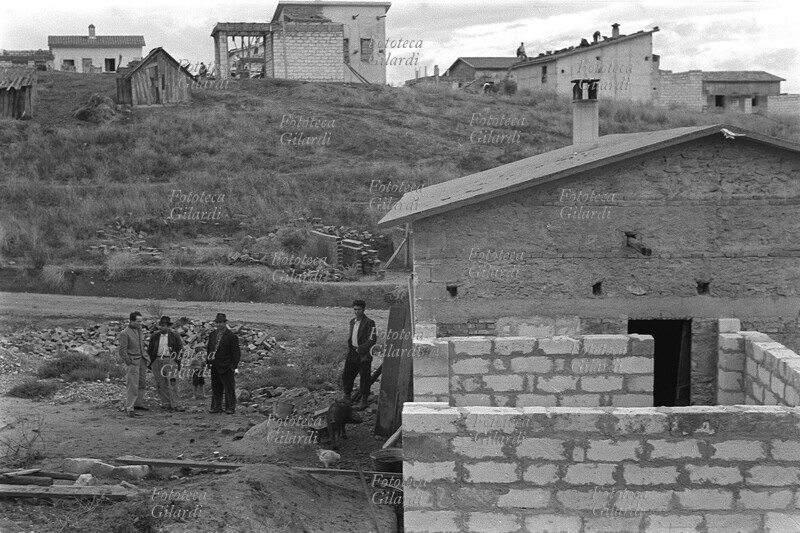 CROTONE assegnatari ampliano la casa sul terreno assegnato, con i blocchi di tufo forniti dal governo. Con il pacchetto di leggi definito Riforma Agraria emanato dal Governo D.C., si distribuirono terreni espropriati ai latifondisti ma incolti da anni e perciò improduttivi, a poveri ex-braccianti disoccupati: questo purtroppo non cambiò la loro tragica situazione di fame e miseria. Fotografia di Ando Gilardi (1921 - 2012) #andogilardi, Crotone 1950.