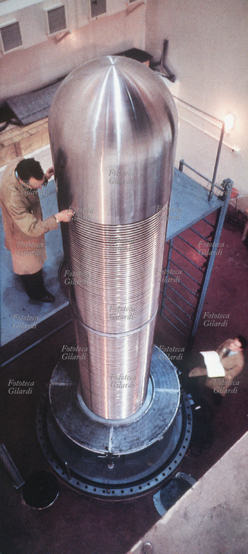 VAN DE GRAAFF generatore di, successivo perfezionamento del generatore elettrostatico di alta tensione, utilizzato nelle ricerche di fisica nucleare come acceleratore di particelle elementari. Il generatore di Van de Graaff è una macchina elettrostatica in grado di accumulare una notevole quantità di carica elettrica in un conduttore, creando tra questo e un elettrodo di riferimento, solitamente messo a terra, un\