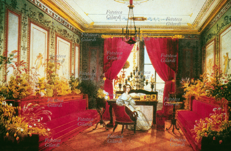 SALOTTO Camera da lavoro giovanile di Maria di Baviera Marie Sophie Amalie von Wittelsbach (1841-1925) nella residenza di Bamberg. Lo studio è arredato con divani e tendaggi rossi e trabocca di piante fiorite. La nobile fanciulla è seduta di fronte a uno scrittoio colmo di ritratti preziosi; le pareti sono decorate in stile pompeiano. Monaco, 1854