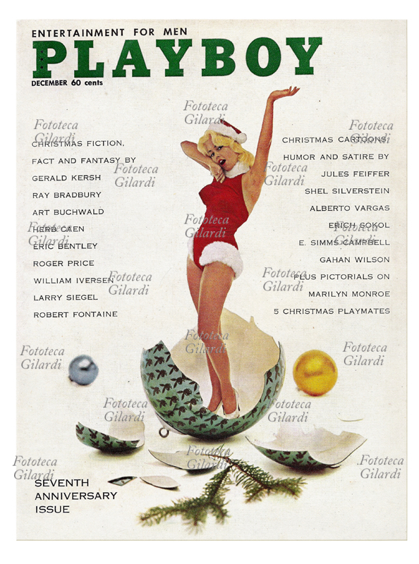 GIORNALI Una pin-up vestita con i colori di Babbo Natale esce come una sorpresa da una pallina di vetro dell\