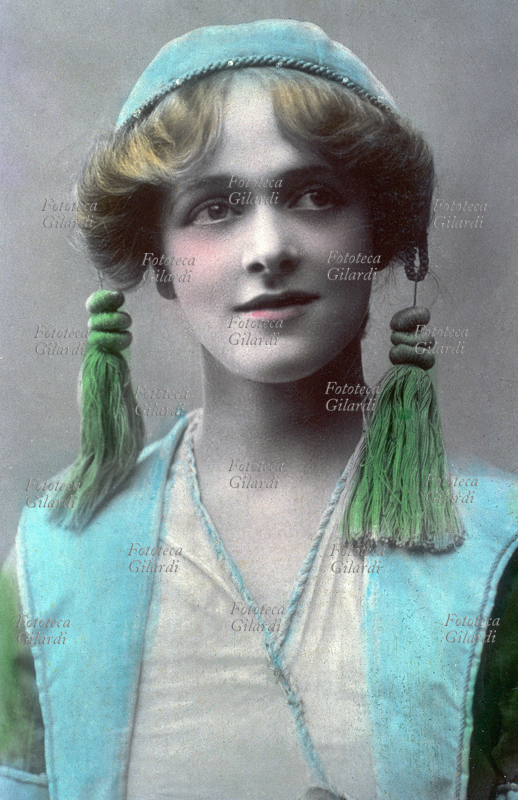 Madge VINCENT (Margaret Bunn, 1884-?) ritratto della giovane attrice e cantante inglese, artista di varietà e pantomima in costume di scena da funambola circense. Fotografia virata seppia, leggermente acquarellata, Londra 1908 circa.