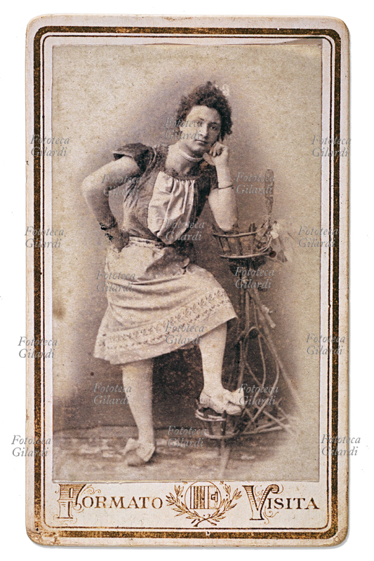 TRAVESTITISMO giovane uomo in abiti femminili in posa, appoggiato ad un portavasi. Fotografia viraggio seppia \