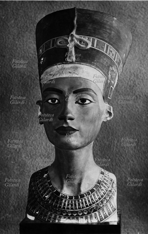 NEFERTITI (ca. 1370 a.C. – ca. 1330 a.C.?), busto della regina egizia della XVIII dinastia, Grande sposa reale del faraone Amenophis IV (1351 a.C. - 1334/3 a.C.) con il quale intraprese la rivoluzione religiosa di stampo enoteistico che poneva unitariamente al centro del pantheon il dio solare Aton (in onore del quale il faraone mutò il proprio nome in Akhenaton), con l\