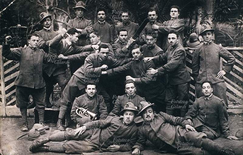 PRIMA GURRA MONDIALE Fotogruppo di alpini che, nella parte centrale del gruppo, mettono in scena scherzosamente una rissa. Fotografia virata seppia, Italia 1915 circa.