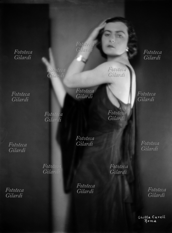 Nicoletta ARRIVABENE VALENTI GONZAGA (1º novembre 1906 – 16 settembre 1986), detta Niki, moglie del conte Edoardo Visconti di Modrone (1908-1980), in raffinato abbigliamento e posa sensuale da femme-fatale. Ritratto fotografico di Ghitta Carell (20 settembre 1899 – 18 gennaio 1972), la fotografa ufficiale dei reali d\