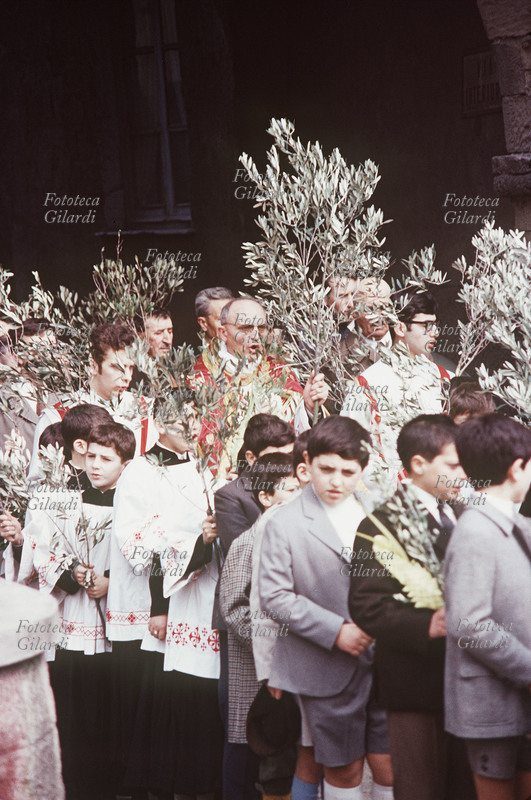PROCESSIONE Parroco, sacerdoti, chierichetti e parrocchiani cantano portando in processione l\