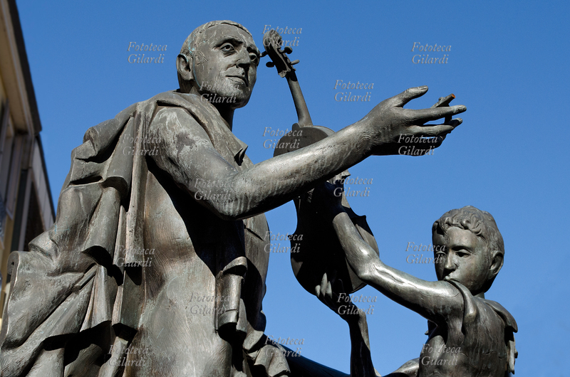 Antonio STRADIVARI (1644 - 18 December 1737), luthier from Cremona, luthier from Cremona, with a child; detail of the bronze sculptural group made in 1999 by the Italian sculptor Floriano Bodini (8 January 1933 - 2 July 2005), as part of the redevelopment works of Piazza Cavour, contextually renamed Piazza Antonio Stradivari. Photograph by Elena Piccini (horizontal cut), Cremona, November 2016