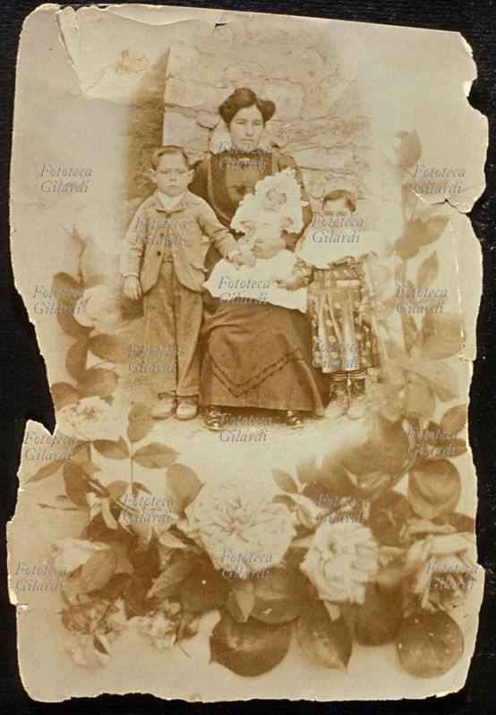 FAMIGLIA giovane madre in posa con i suoi tre bambini: il più anziano di età intorno ai cinque anni e il più giovane di pochi mesi. Il neonato, l\