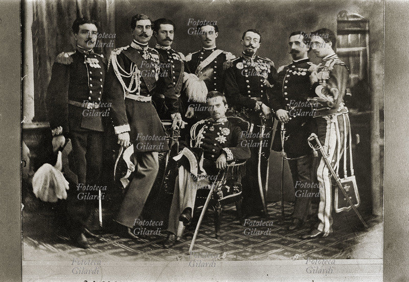 UMBERTO I di Savoia (1844-1900) seduto, con il suo Stato Maggiore: da sin.: Capitano cagni, Generale Villamarina, Capitano Granatieri Gianotti, Capitano cavalleria Bertola, Colonnello De Sonnaz, Capitano fanteria Boni, Capitano Guide Brambilla. Italia, 1866