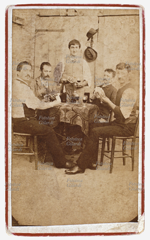 VINO Interno di osteria: quattro amici giocano a carte al tavolino, l\