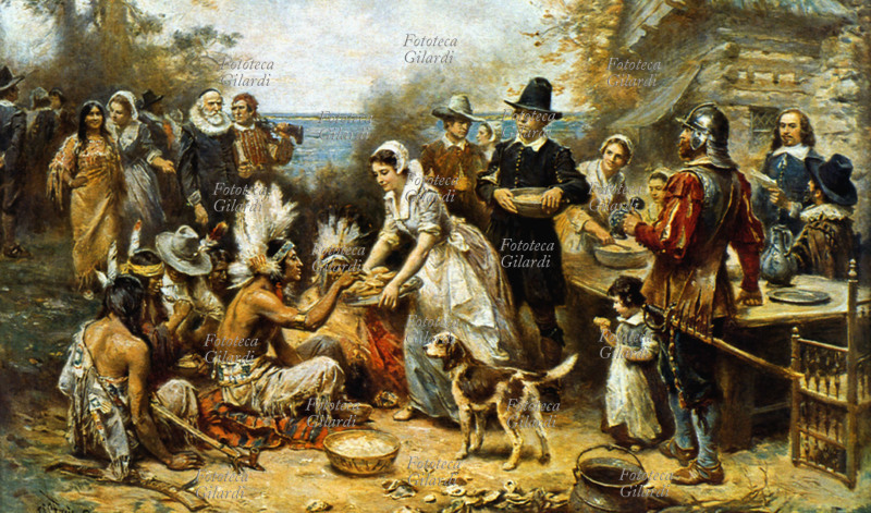 PURITANI Il primo Giorno del Ringraziamento in America. Litografia da dipinto di J.L.G. Ferris raffigurante i Padri Pellegrini, primi coloni inglesi approdati in America, che fanno amicizia e dividono il cibo con le popolazioni indigene. Era il 9 novembre 1620