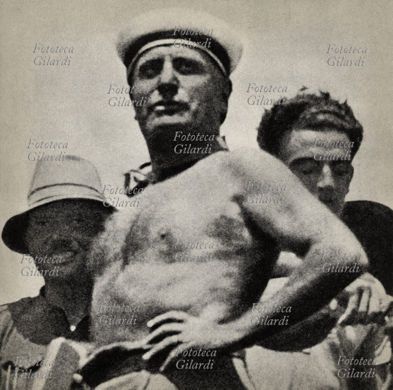 Benito MUSSOLINI (1883-1945) posa a torso nudo con le mani sui fianchi durante la trebbiatura nella zona dell\