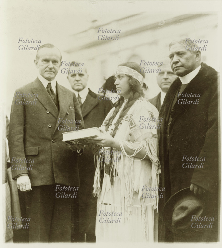 U.S.A Ruth Muskrat (3 ottobre 1897 – 12 giugno 1982), poetessa nativa americana Cherokee, educatrice e attivista per i diritti degli indiani, rende omaggio al Presidente Calvin Coolidge (4 luglio 1872 – 5 gennaio 1933) con una copia del libro \