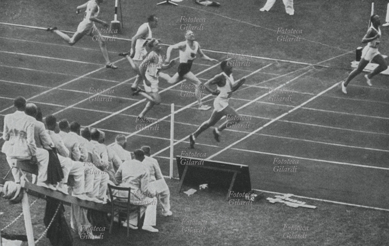 Jesse OWENS (12 settembre 1913 – 31 marzo 1980) taglia vittorioso il traguardo dei 100 m. piani nel tempo record di 10"2, seguito dal connazionale Ralph Metcalfe (29 maggio 1910 – 10 ottobre 1978) e dall\