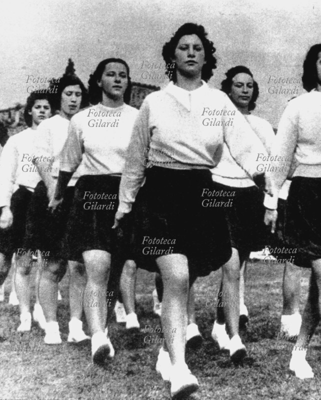 GIOVANI ITALIANE si recano marciando a un saggio ginnico. Ragazze dai 14 ai 18 anni dell\
