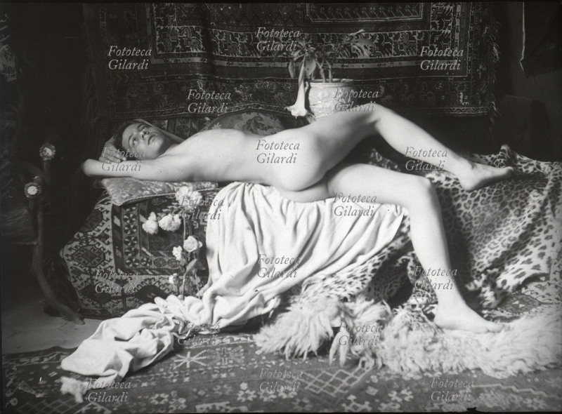 EROS Ragazzo sognante. Nudo maschile, molto casto ma sensuale, sdraiato su cuscini e tappeti. Fotografia attribuita a Wilhelm von Plüschow (1852-1930), Italia circa 1900