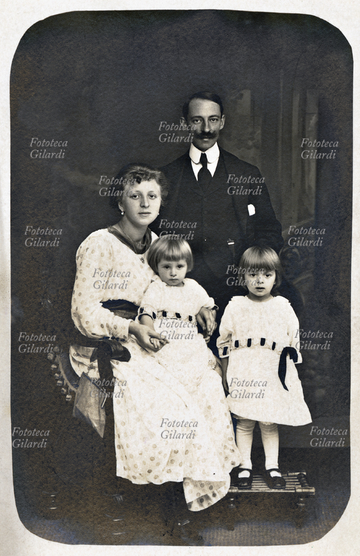 FAMIGLIA Padre, madre e due bimbe di bianco vestite posano per una fotografia ricordo. Lovere (Bergamo), anni 1910 - 1919