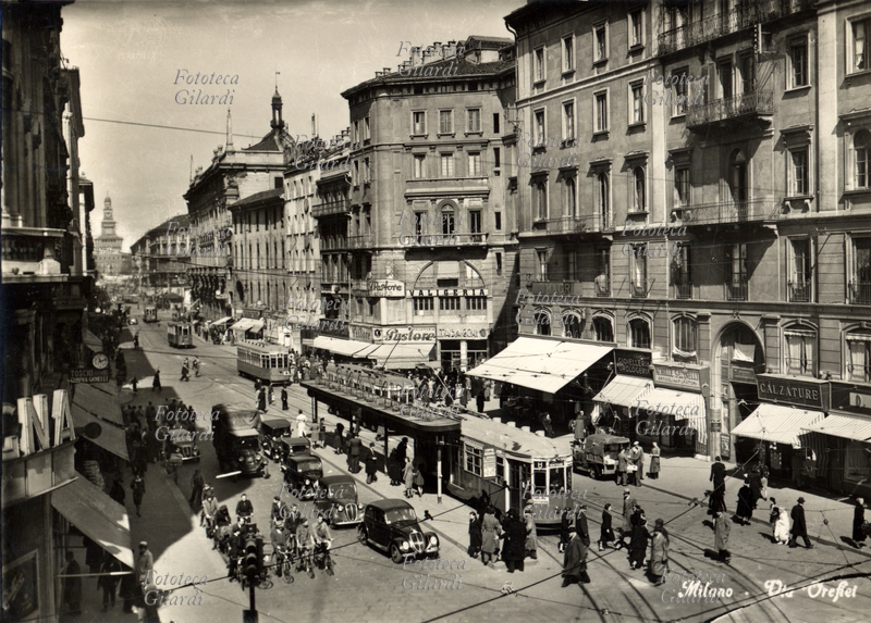 MILANO Via Orefici, intenso il traffico di auto, mezzi pubblici, furgoni, biciclette, moto, pedoni. Cartolina fotografica, 1950