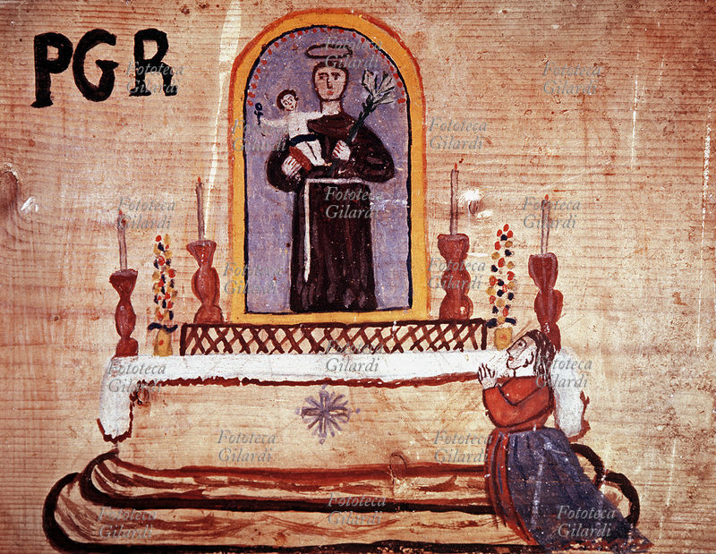 EX-VOTO, esemplare dipinto su tavola di legno grezzo. P G R (n.d.r. Per Grazia Ricevuta). La donna graziata prega davanti all\