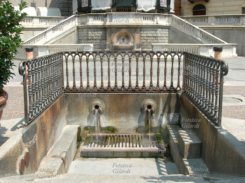 ACQUI TERME veduta di Piazza della Bollente in primo piano la fonte e la fontana dellacqua sulfurea che raggiunge la temperatura di 75°. Tra il 1870 ed il 1880 un intervento dellamministrazione comunale trasformò radicalmente lantichissima area sorta intorno alla fonte omonima demolendo anche il Ghetto. Allingegnier Ceruti si deve ledicola-tempietto in stile eclettico coperta da ponteggi per restauro al momento della ripresa, qui appena visibili nella parte superiore dell\