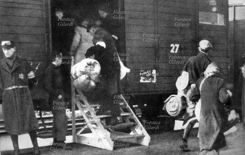 SHOAH ebrei deportati salgono sui treni che dai ghetti portano ai campi di sterminio. Ignari del loro destino, hanno raccolto tutti ciò che potevano trasportare dei loro averi in grossi fagotti. Fotografia, Amsterdam, autunno 1944.