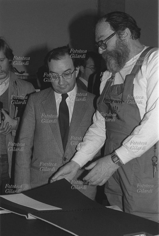 STORIA DELLA FOTOGRAFIA Carlo Tognoli (16 giugno 1938 – 5 marzo 2021), sindaco di Milano, in visita allo stand di Foto/gram, gruppo di ricerca fotografica fondato e diretto da Ando Gilardi (8 giugno 1921 - 5 marzo 2012). IX Sicof (Salone Internazionale Cine Foto Ottica) Sezione Culturale, Fiera di Milano, 1981.