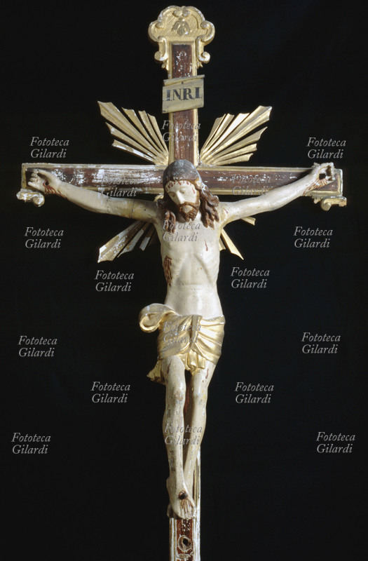 CRISTO crocifisso in legno, da restaurare nei raggi di luce dietro la croce. Scultura di anonimo, Italia XVI secolo.