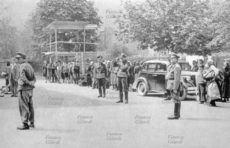 II GM JUGOSLAVIA Resistenza: deportazione delle famiglie di ostaggi fucilati. Concentramento nella piazza del mercato; un ufficiale tedesco, al centro della scena, prende una fotografia ricordo: i ragazzi sono separati dalle madri e inviati negli speciali istituti di denazionalizzazione \