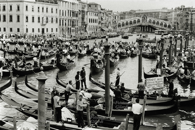 SCIOPERO dei gondolieri contro il moto ondoso provocato dai trasporti pubblici che ostacolano il loro lavoro e monopolizzano il traffico turistico. Ammassati con le imbarcazioni nel Canal Grande nei pressi del ponte di Rialto, su un cartello si legge un ironico: \
