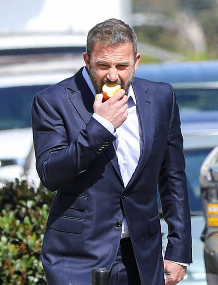 Santa Monica Ben Affleck in un elegante completo blu mentre addenta una mela Santa Monica Ben Affleck in un elegante completo blu mentre addenta una mela