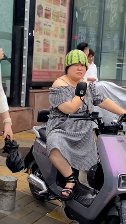 Woman Riding Scooter Uses Half Watermelon For Helmet