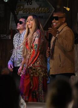 Jennifer Lopez wears a low cut red wrap dress with shimmering gold sequins as she is seen filming a music video