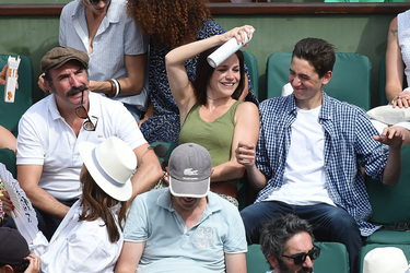 Jean Dujardin and his wife Nathalie Pechalat keep each other moisturised at the French Tennis Open at Roland Garros