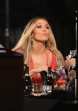 Jennifer Lopez wears a low cut red wrap dress with shimmering gold sequins as she is seen filming a music video