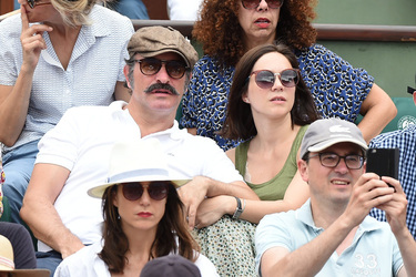Jean Dujardin and his wife Nathalie Pechalat keep each other moisturised at the French Tennis Open at Roland Garros