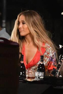Jennifer Lopez wears a low cut red wrap dress with shimmering gold sequins as she is seen filming a music video