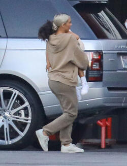 Kim Kardashian carrying a sleepy princess Nori