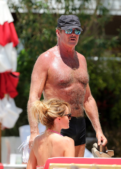Baywatch actor David Hasselhoff wears tiny black swim trunks as he relaxes with his bikini clad finance Hayley Roberts by the pool in Miami.