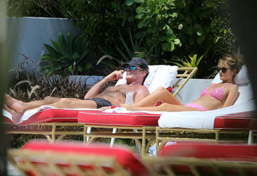 Baywatch actor David Hasselhoff wears tiny black swim trunks as he relaxes with his bikini clad finance Hayley Roberts by the pool in Miami.