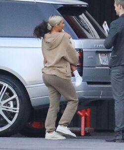 Kim Kardashian carrying a sleepy princess Nori