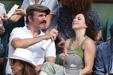 Jean Dujardin and his wife Nathalie Pechalat keep each other moisturised at the French Tennis Open at Roland Garros